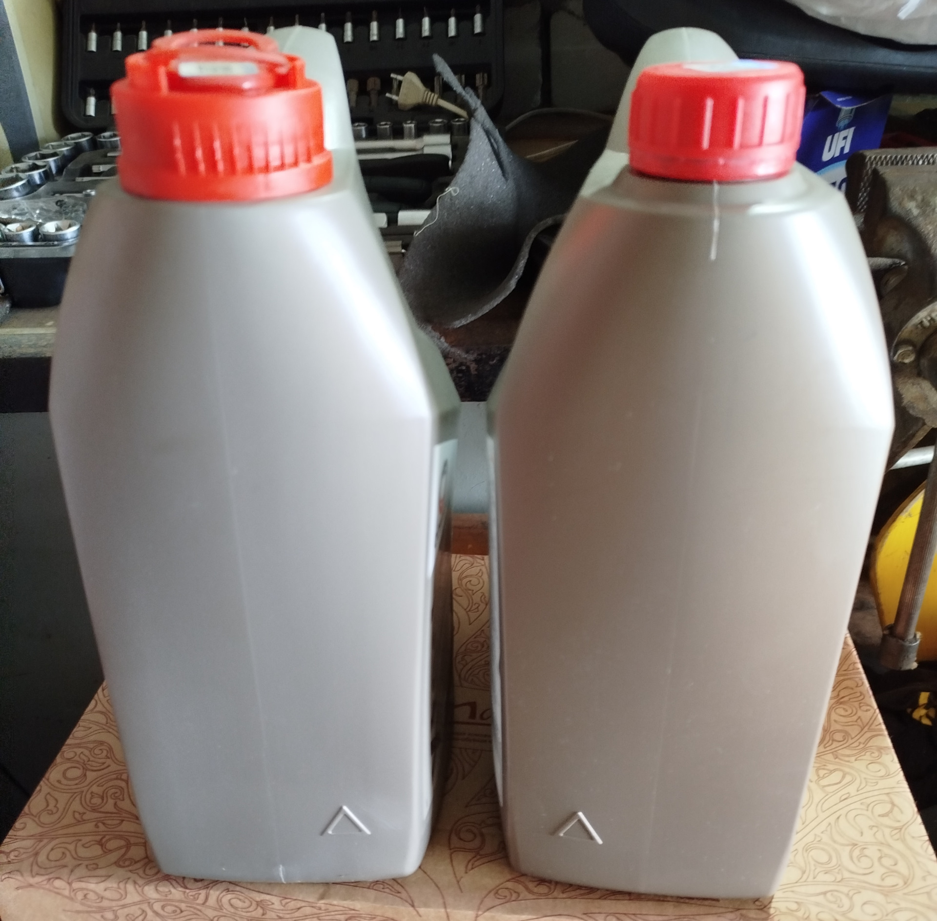 Две канистры COMMA XTECH 5W-30 рядом: у левой крышка с пломбой-ушком, у правой — гладкая без пломбы